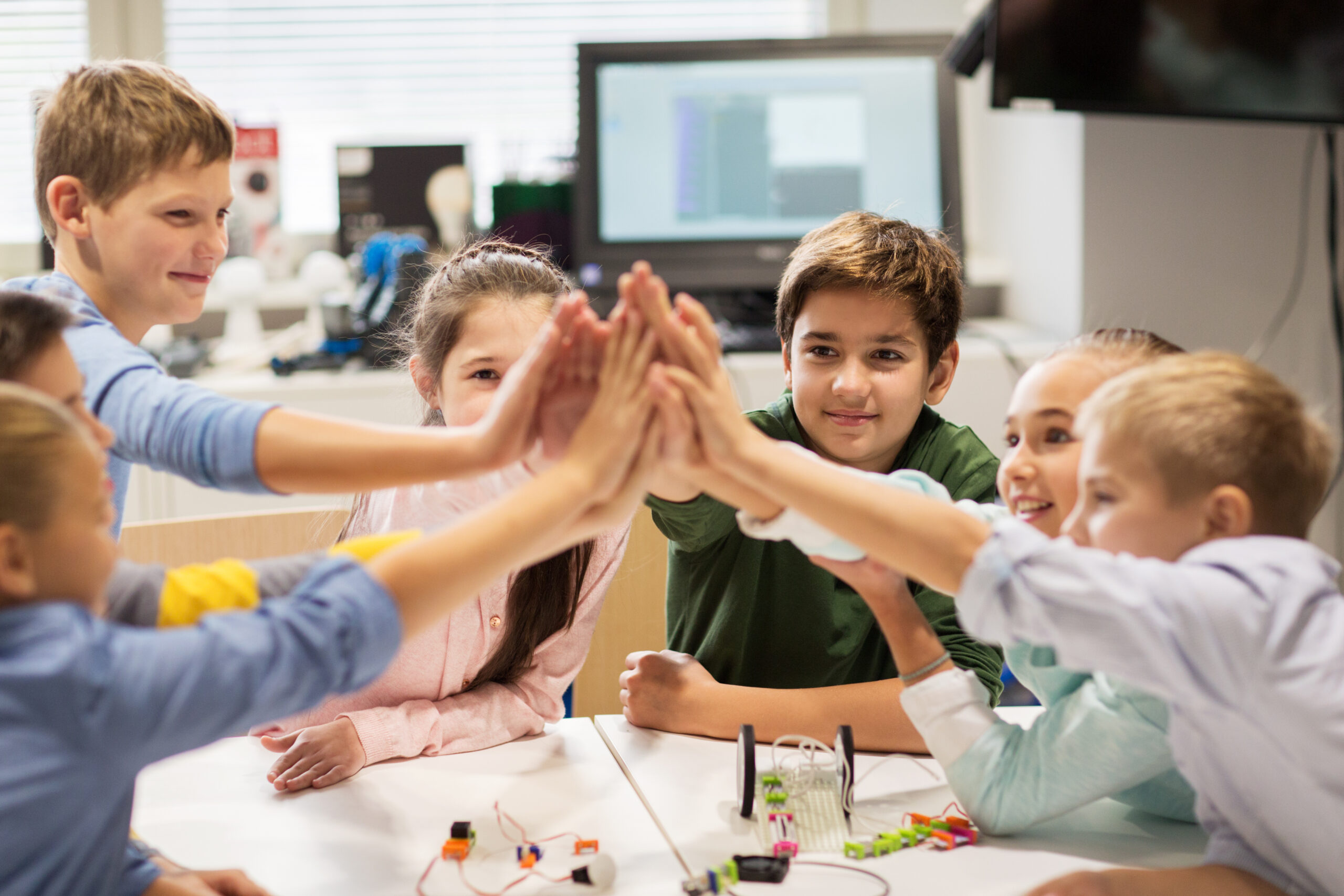 happy children making high five at robotics school